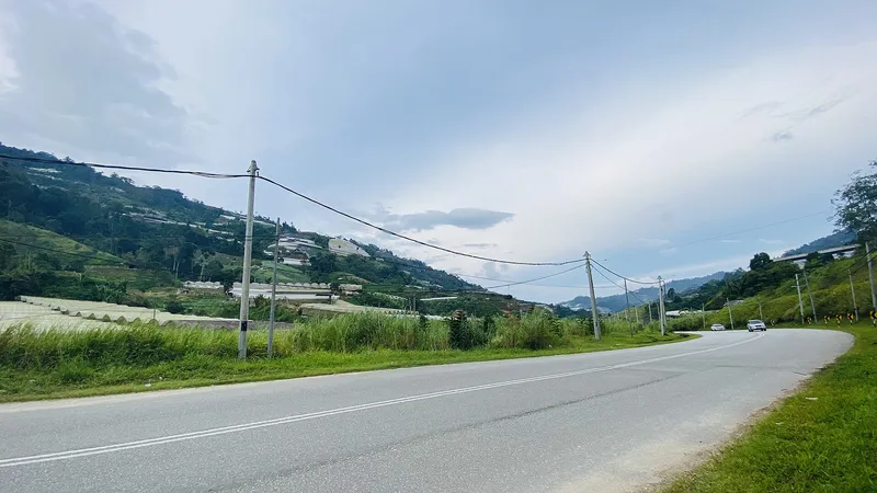 Federal Route 102 running through the Bertam valley, farms on the hills
