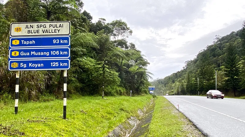 Road sign on Federal Route 185 with distances to Tapah, Gua Musang and Sungai Koyan